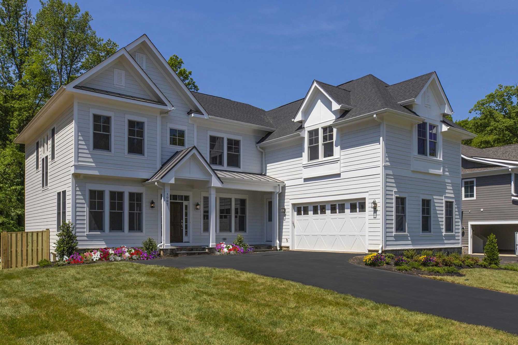 The Aiden II elevation — a shingle-and-stone facade with a deep front porch and three-car garage